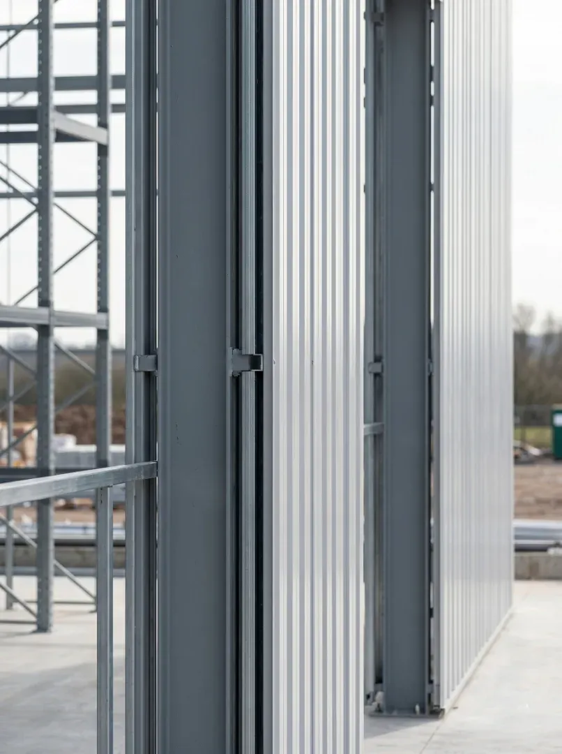 Exterior wall cladding panels mounted directly onto heavy duty pallet rack uprights